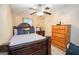 Well-lit bedroom featuring a queen bed, a ceiling fan, and a classic wooden dresser at 1346 Revelstoke Cv, Riverdale, GA 30296