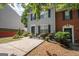 Attractive townhome showcasing a neatly landscaped yard, mature bushes and a concrete driveway at 1346 Revelstoke Cv, Riverdale, GA 30296