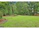 Beautifully landscaped backyard with mature trees and lush green grass, perfect for outdoor enjoyment at 226 Long Island Dr, Whitesburg, GA 30185