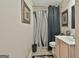 Neutral bathroom featuring a shower with black and white curtains and artwork on the walls at 226 Long Island Dr, Whitesburg, GA 30185