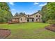 The rear of the home features a well-manicured lawn, a deck, and large glass windows at 226 Long Island Dr, Whitesburg, GA 30185