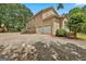 Large home with a spacious driveway and a two-car garage nestled among mature trees at 226 Long Island Dr, Whitesburg, GA 30185