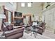 Large living room with comfortable brown leather furniture, high ceilings, and a fireplace at 226 Long Island Dr, Whitesburg, GA 30185