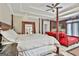 Main bedroom featuring a four-poster bed, tray ceilings, and a sitting area with a fireplace at 226 Long Island Dr, Whitesburg, GA 30185