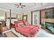 Main bedroom featuring a four-poster bed, tray ceilings, fireplace, and sitting area with red couches at 226 Long Island Dr, Whitesburg, GA 30185
