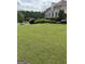 Expansive front yard featuring healthy lawn, manicured shrubbery, and mature trees at 2360 Barrington Trace Sw Cir, South Fulton, GA 30331