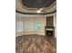 Living room with wood-look floors, gas fireplace, and natural light from three windows at 2360 Barrington Trace Sw Cir, South Fulton, GA 30331