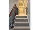 A view of the carpeted staircase featuring an elegant wood and metal railing, leading to the upper level at 2360 Barrington Trace Sw Cir, South Fulton, GA 30331