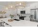 Close-up of the kitchen island featuring pendant lights, bar stools, and stainless steel appliances at 3349 Verdi Ln, Kennesaw, GA 30144