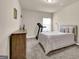 Simple bedroom with a bed, dresser, and treadmill near a window at 675 Mallard Cv, Loganville, GA 30052