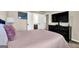 A modern bedroom featuring a TV mounted above a dark dresser, and a view to the ensuite at 675 Mallard Cv, Loganville, GA 30052