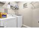 Convenient laundry room equipped with a washer, dryer, and shelving for storage at 675 Mallard Cv, Loganville, GA 30052