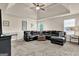 Spacious living room featuring a black leather sectional sofa, tray ceiling and dark furnishings at 675 Mallard Cv, Loganville, GA 30052