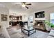 Open-concept living space with kitchen view, stone fireplace, TV, and comfortable seating at 675 Mallard Cv, Loganville, GA 30052