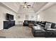 Spacious living room featuring a black leather sectional sofa, tray ceiling and dark furnishings at 675 Mallard Cv, Loganville, GA 30052