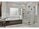 Luxury bathroom with a soaking tub, walk-in shower, and marble tile surround at 210 Short Rd, Sharpsburg, GA 30277