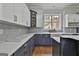 Well-appointed kitchen featuring blue cabinetry, white countertops, and a farmhouse sink with a window view at 210 Short Rd, Sharpsburg, GA 30277