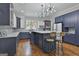 Bright, open kitchen with a stylish island, modern lighting, and contrasting blue and white cabinetry at 210 Short Rd, Sharpsburg, GA 30277