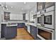 Gourmet kitchen featuring stainless appliances, blue and white cabinets and countertops and stylish backsplash at 210 Short Rd, Sharpsburg, GA 30277