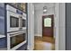 Modern kitchen featuring built-in ovens and cabinets with glass doors at 210 Short Rd, Sharpsburg, GA 30277