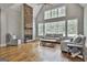 Spacious living room featuring hardwood floors, a stone fireplace, and large windows that flood the space with natural light at 210 Short Rd, Sharpsburg, GA 30277