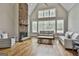 Bright living room featuring a stone fireplace, hardwood floors, and vaulted ceilings with lots of windows at 210 Short Rd, Sharpsburg, GA 30277