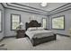 Main bedroom with a luxurious bed, elegant nightstands, and a decorative tray ceiling at 210 Short Rd, Sharpsburg, GA 30277