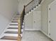 Elegant staircase with wooden banister, white risers, and carpet runner at 210 Short Rd, Sharpsburg, GA 30277