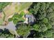 An aerial view of a charming home nestled among lush greenery with a private driveway and well-maintained lawn at 3600 Goldenrod Dr, Alpharetta, GA 30005