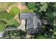 An aerial view of a gray roofed home with a curved driveway surrounded by lush greenery and trees at 3600 Goldenrod Dr, Alpharetta, GA 30005