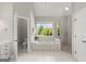 Bright bathroom featuring soaking tub, walk-in shower, white cabinets and tile floor at 3600 Goldenrod Dr, Alpharetta, GA 30005