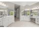 Large bathroom with dual vanities, mirrors, decorative lighting, and separate shower at 3600 Goldenrod Dr, Alpharetta, GA 30005