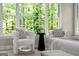 Bright bedroom seating area featuring large windows with wooded view and plush chairs at 3600 Goldenrod Dr, Alpharetta, GA 30005