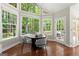 Breakfast nook with a black table and four chairs surrounded by many windows to view the backyard at 3600 Goldenrod Dr, Alpharetta, GA 30005