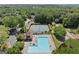 Aerial view of the community amenities, a pool, tennis courts, and clubhouse surrounded by trees at 3600 Goldenrod Dr, Alpharetta, GA 30005