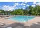 Community pool featuring an L-shaped pool surrounded by lounge chairs and picnic tables at 3600 Goldenrod Dr, Alpharetta, GA 30005