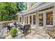 Exterior back deck featuring stylish outdoor seating with a view of the home's multiple windows and french doors at 3600 Goldenrod Dr, Alpharetta, GA 30005