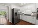 Kitchen with stainless appliances, granite countertops, and hardwood floors with an opening to the dining room with windows at 3600 Goldenrod Dr, Alpharetta, GA 30005