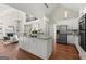 Bright kitchen with a large island, stainless appliances, and hardwood floors that flows to the living room with fireplace at 3600 Goldenrod Dr, Alpharetta, GA 30005