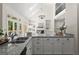 Bright kitchen featuring granite countertops, stainless sink and white cabinets with a view to the living room with a fireplace at 3600 Goldenrod Dr, Alpharetta, GA 30005