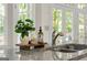 Close up of kitchen counter featuring granite countertops, stainless sink, faucet and decor with a view to the backyard at 3600 Goldenrod Dr, Alpharetta, GA 30005