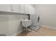 Well-lit laundry room with washer-dryer and white utility sink and ample cabinet space at 3600 Goldenrod Dr, Alpharetta, GA 30005