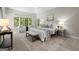 Light-filled bedroom with a king-size bed, neutral decor, and scenic backyard views at 3600 Goldenrod Dr, Alpharetta, GA 30005
