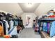 A fully stocked walk-in closet with a sloped ceiling and carpeted floors at 10736 Southwood Dr, Hampton, GA 30228