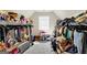 Fully stocked walk-in closet with seating and sloped ceiling at 10736 Southwood Dr, Hampton, GA 30228