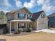 Lovely two-story brick home showcasing a covered front porch and an attached two-car garage at 10736 Southwood Dr, Hampton, GA 30228