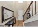Bright foyer featuring hardwood floors, a staircase, and a decorative table with a mirror at 10736 Southwood Dr, Hampton, GA 30228