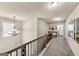 Carpeted hallway upstairs with wood railings and a chandelier at 10736 Southwood Dr, Hampton, GA 30228