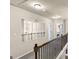 Hallway on second floor looking down to first floor with chandelier in view at 10736 Southwood Dr, Hampton, GA 30228