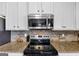 Modern kitchen featuring a stainless steel microwave, oven, and stylish backsplash at 10736 Southwood Dr, Hampton, GA 30228